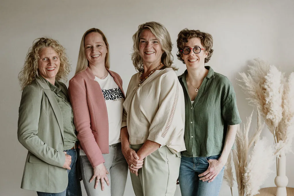 De echoscopisten Deborah, Joan en Evelien en assistente Ineke staan dicht bij elkaar en lachen naar de camera